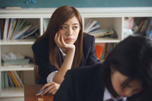 a girl staring off in a classroom