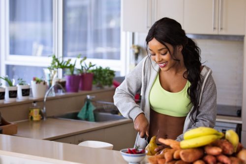 girl cutting up some fruit after a workout