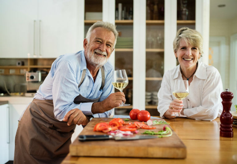 older couple enjoying retirement and a glass of white wine