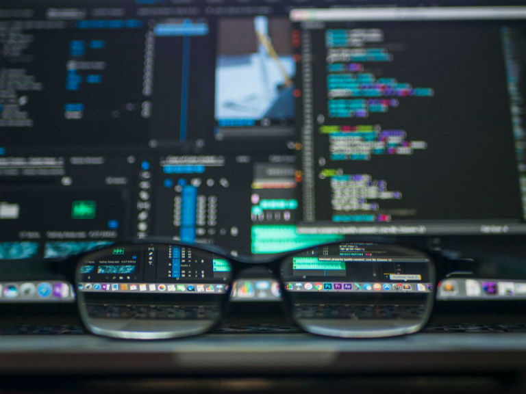 glasses looking at hacker computer screen