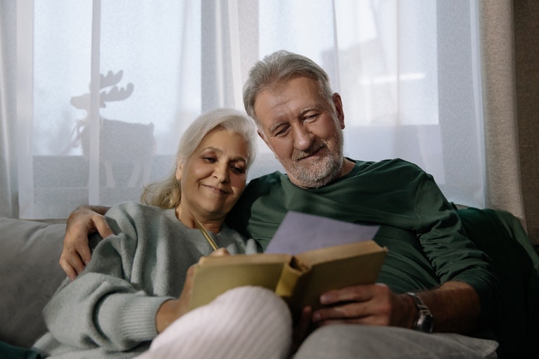 couple sitting on couch and smiling at IRA form