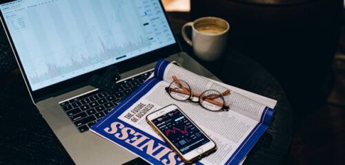business newsletter reading laptop desk coffee